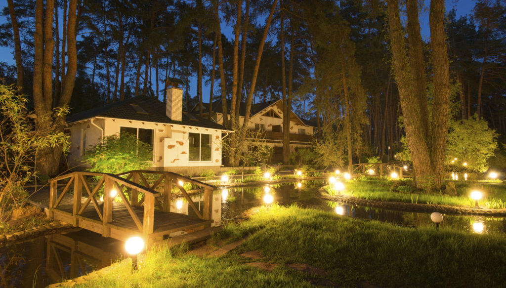 Landscape Lighting in Front of White Brick House at Night